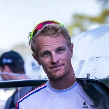 Luc Daffarn wearing a white rowing top with sunglasses on his head